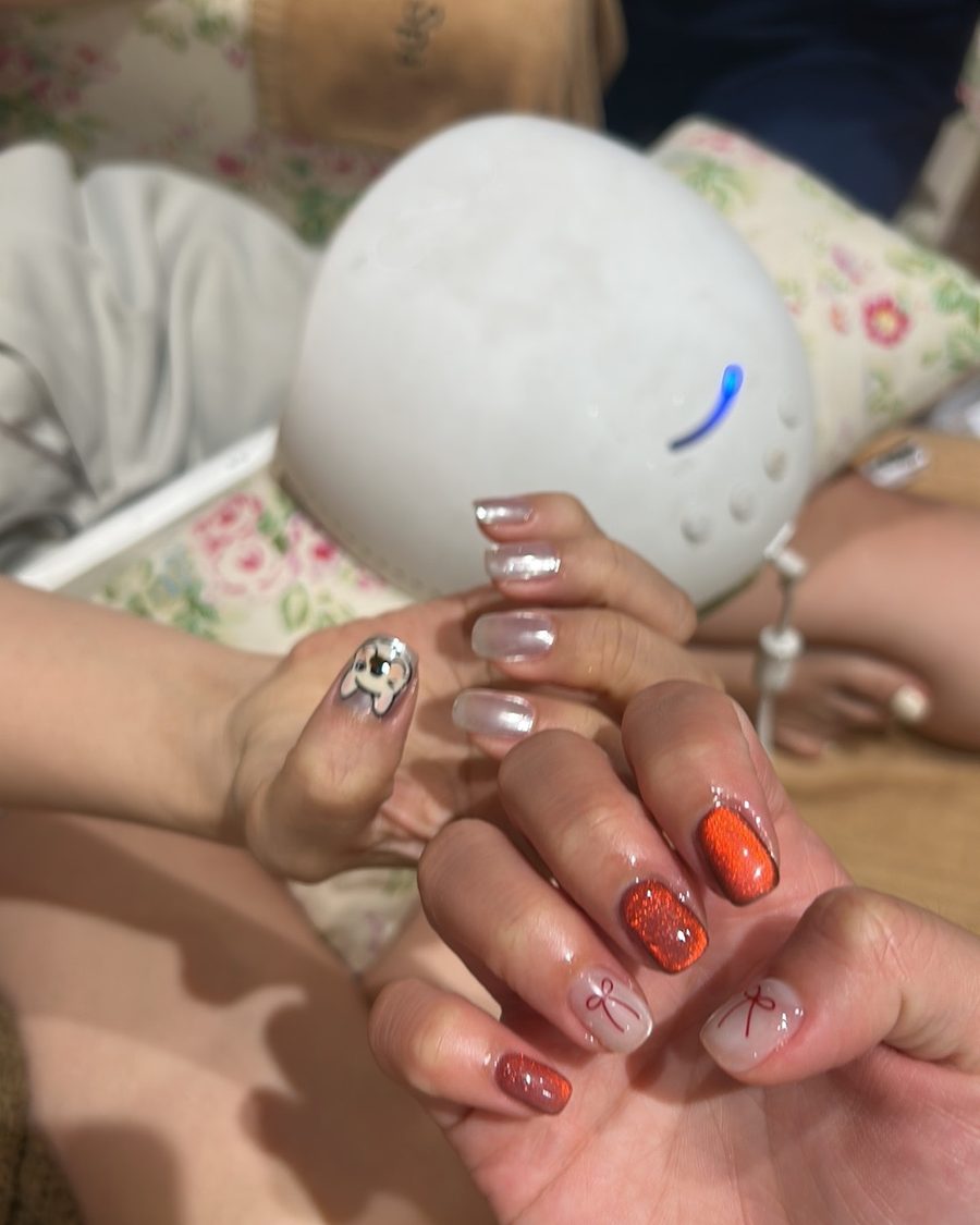 Sheer nails with red and gold hand painted art.