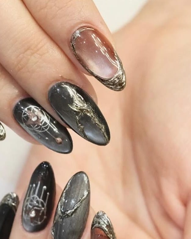 A full set of black marble nails with gold veining.