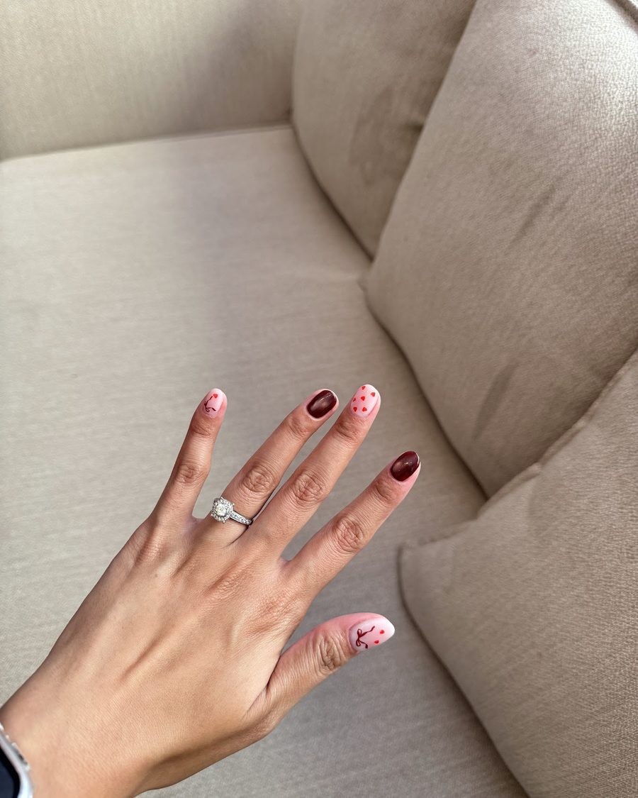 Red and pink hand painted art on a hand resting on the sofa.